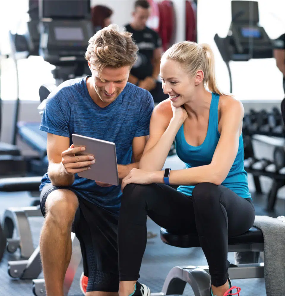 Man and woman looking at gym management software on a tablet